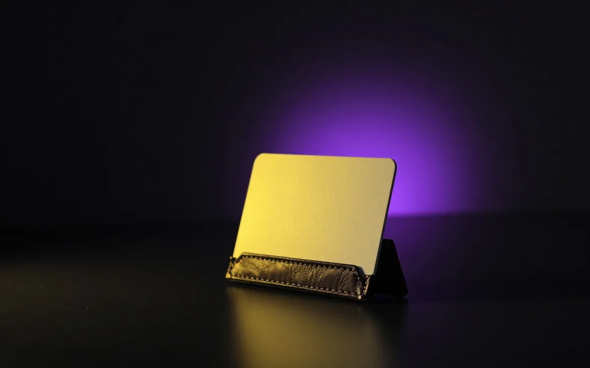 A card holder with one blank card raised on a black table
